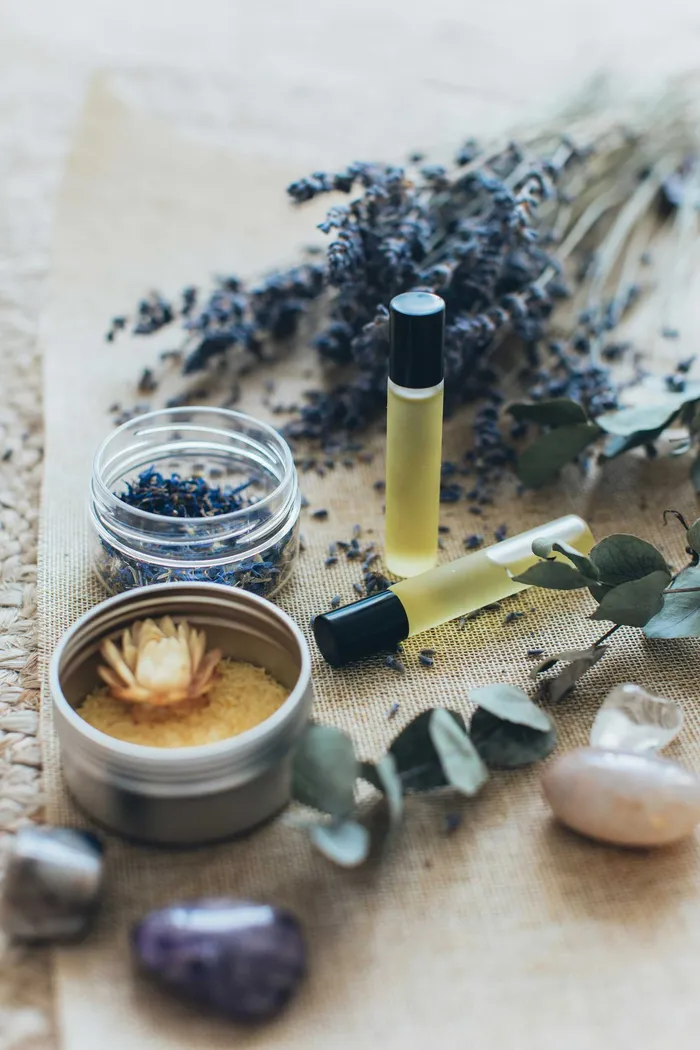 Aromatherapie-Arrangement mit Lavendel, Öl-Rollern und Kristallen.